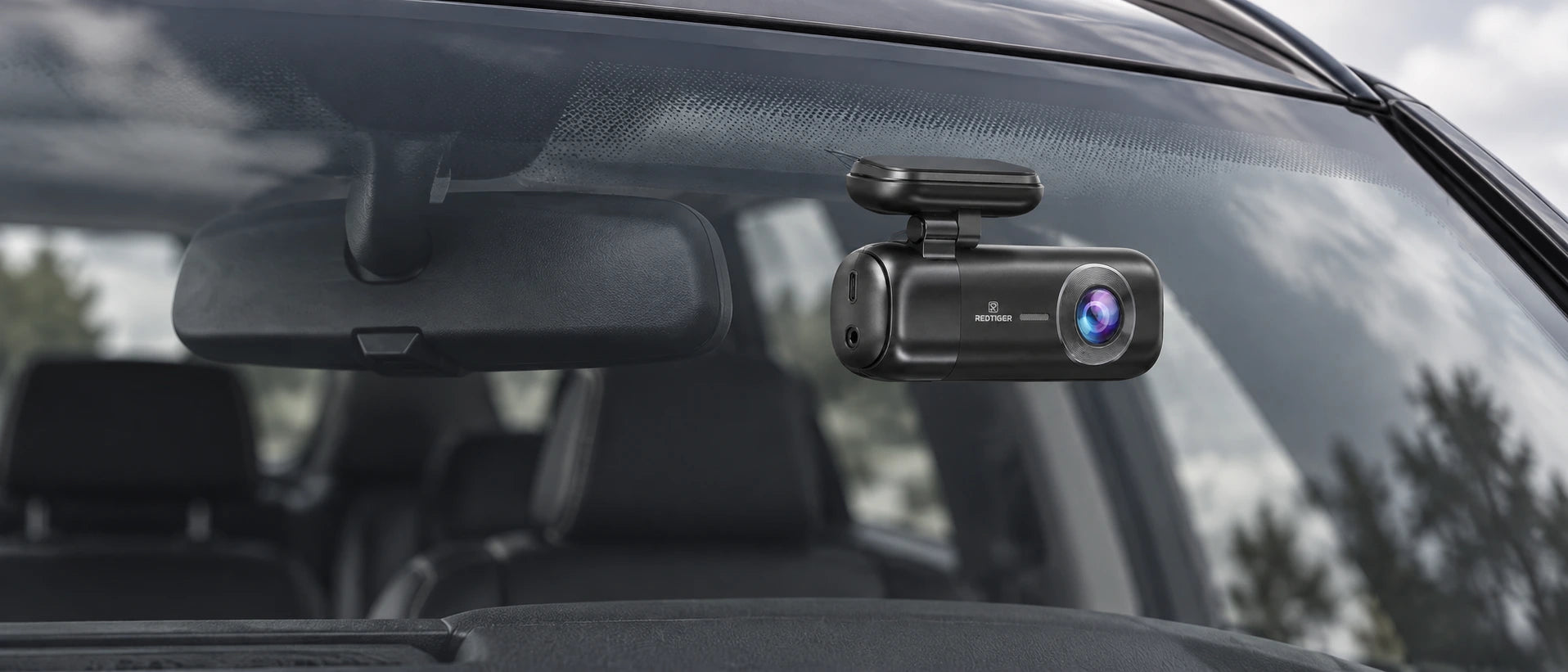 Une voiture arrêtée dans un paysage lumineux, équipée d’une petite dashcam F9
